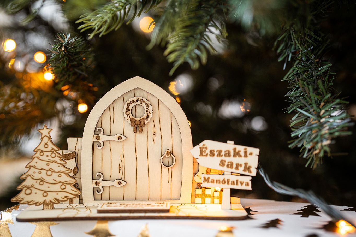 Fa man&oacute;ajt&oacute; fenyőf&aacute;val &eacute;s &Eacute;szaki-sark Man&oacute;falva t&aacute;bl&aacute;val